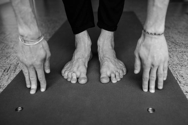 Close up of hands stretching towards feet during a flexibility session